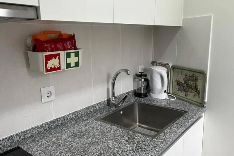 Bancada da cozinha com lava-loiça, cafeteira e chaleira