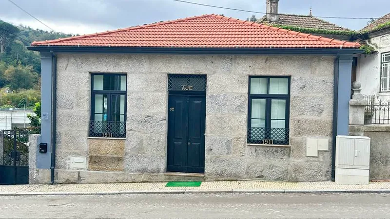 The granite façade and blue door of Chalé Caldas de Aregos